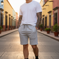 A person wearing gray fleece shorts with an elastic waistband and drawstring, featuring a front pocket and printed text on the left leg.