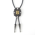 Gray bolo tie with ornate silver pendant and gold letter B center.