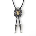 Gray bolo tie with ornate silver pendant and gold letter V center.