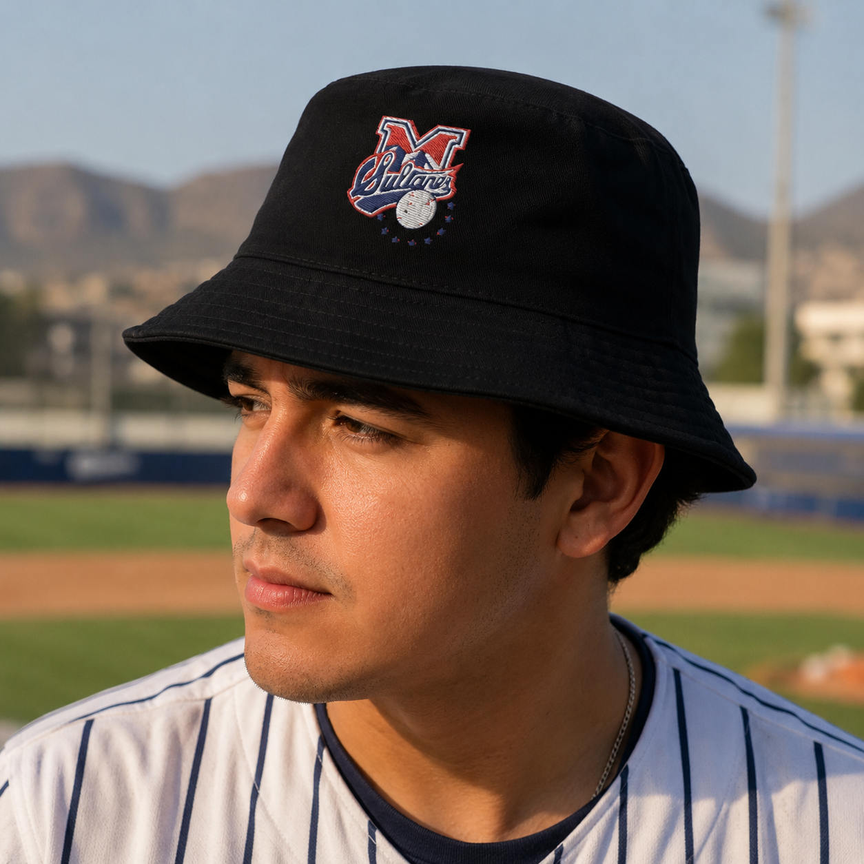 A Mexican model wearing the Sultanes de Monterrey bucket hat in a realistic outdoor lifestyle setting, with the front design clearly visible. The Sultanes de Monterrey bucket hat design, shape, and colors are shown clearly in a natural casual scene.