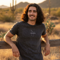 A person wearing a black denim t-shirt with the text 'tlaxcala' on the front.