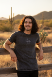 A person wearing a black denim t-shirt with the text 'tlaxcala' on the front.