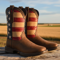 A pair of men's square toe western boots with a patriotic brown and multicolor print on the upper, featuring a low heel and a slip-on design.